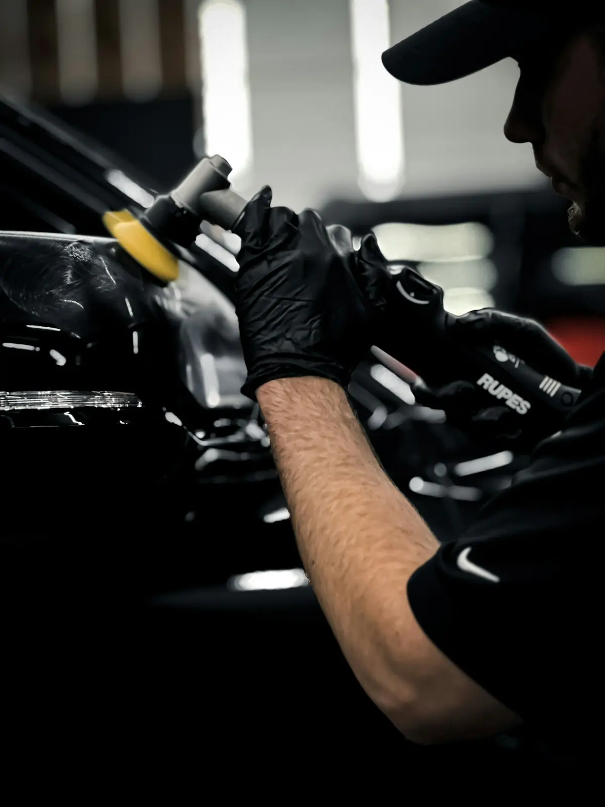 Gloved hands working on a black car