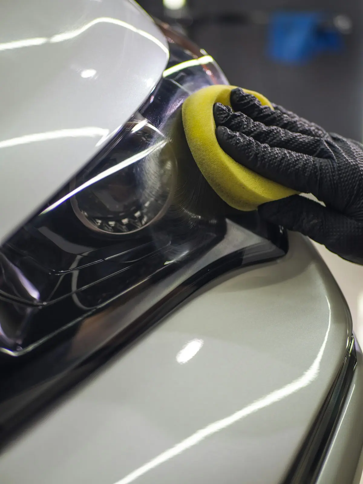 Gloved hand working on a headlight lens